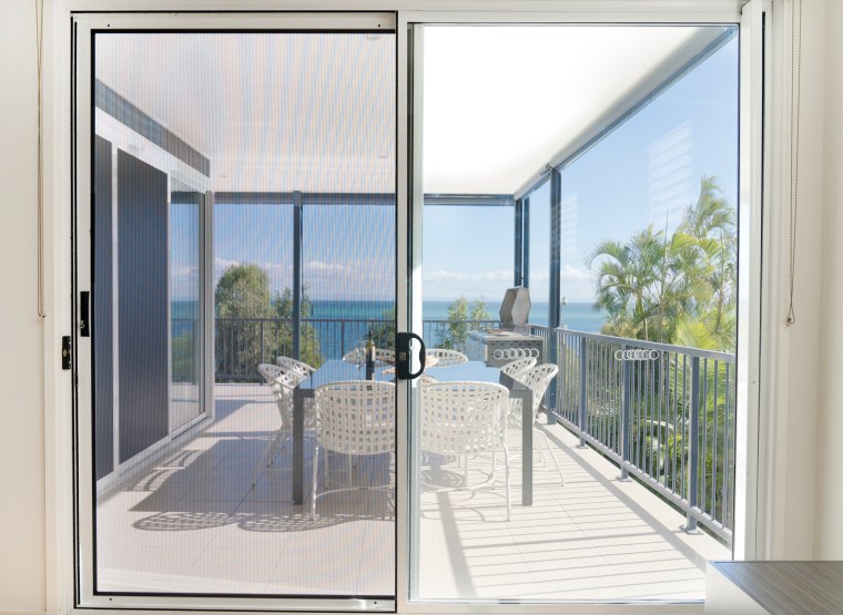 Sliding security screen door overlooking a coastal balcony