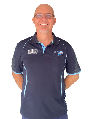 Chad from Jacks Glass is smiling at the camera wearing a blue uniform shirt